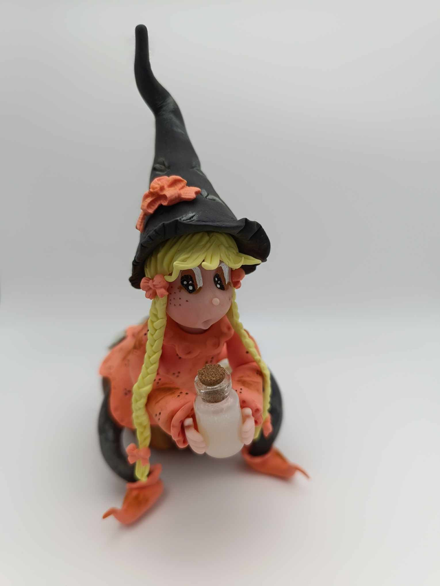 Sorcière en porcelaine froide sur citrouille