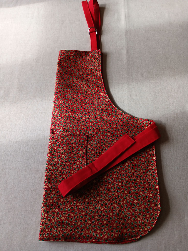Childs Kitchen Play Apron Red Cotton Fabric with Gold Holly Print, Front pocket and Red lining, waist ties and adjustable neck ties 