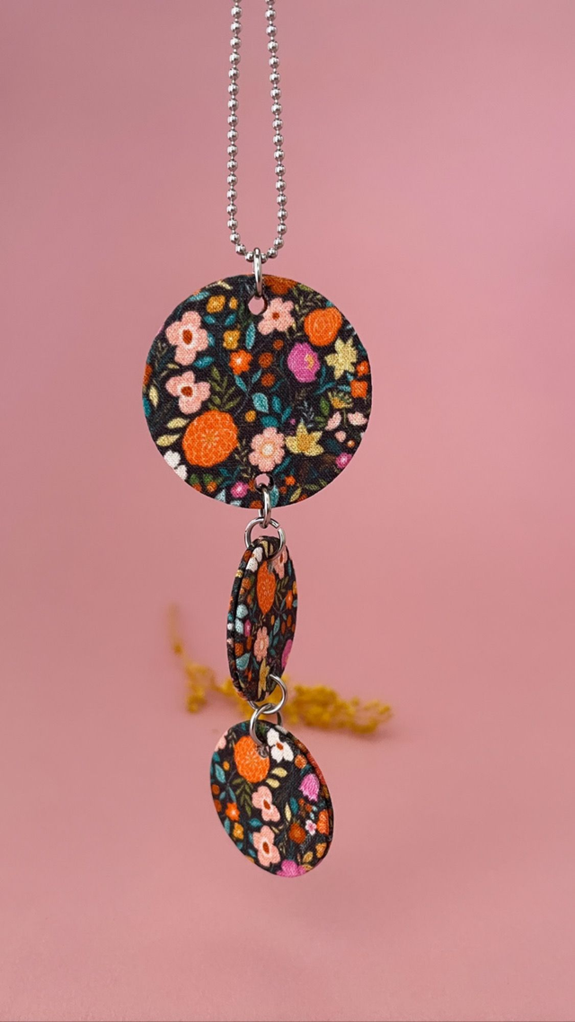 Collier avec pendentif en carton et tissu fleuri, composé de trois cercles, collection "1001 fleurs", fond noir et motifs fleuris multicolores