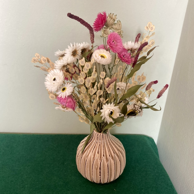 Local dried flower arrangement in vintage beige glazed vase