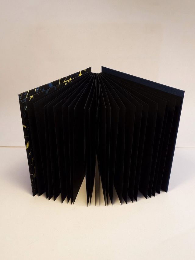 Album foto nero con cucitura copta e schizzi gialli e blu