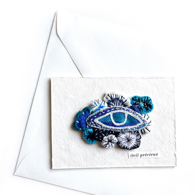Œil fleuri peint et brodé, appliqué sur carte en papier artisanal