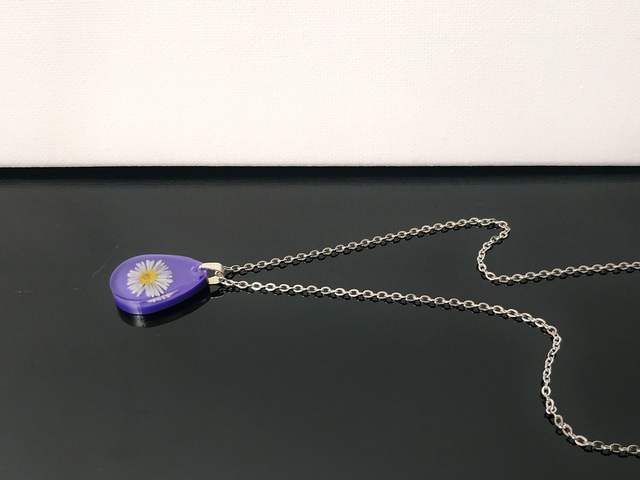 Collier fleur de pâquerette sur fond violet