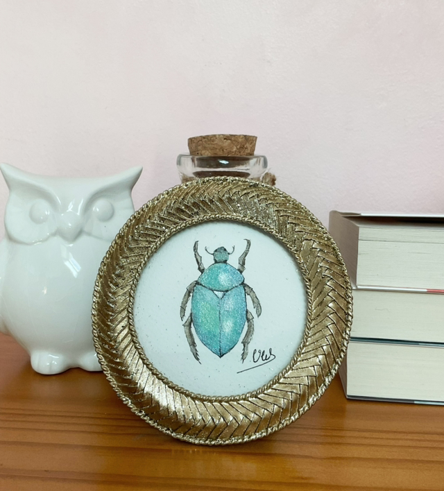 Scarabée bleu irisé dans son cadre miniature doré