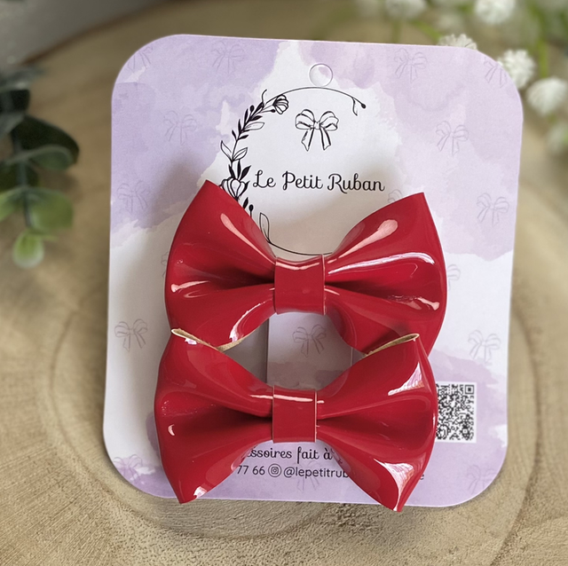 Paire de petites barrettes brilhantes rouges.