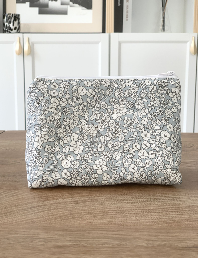 Trousse de toilette fleurie sur fond gris bleuté