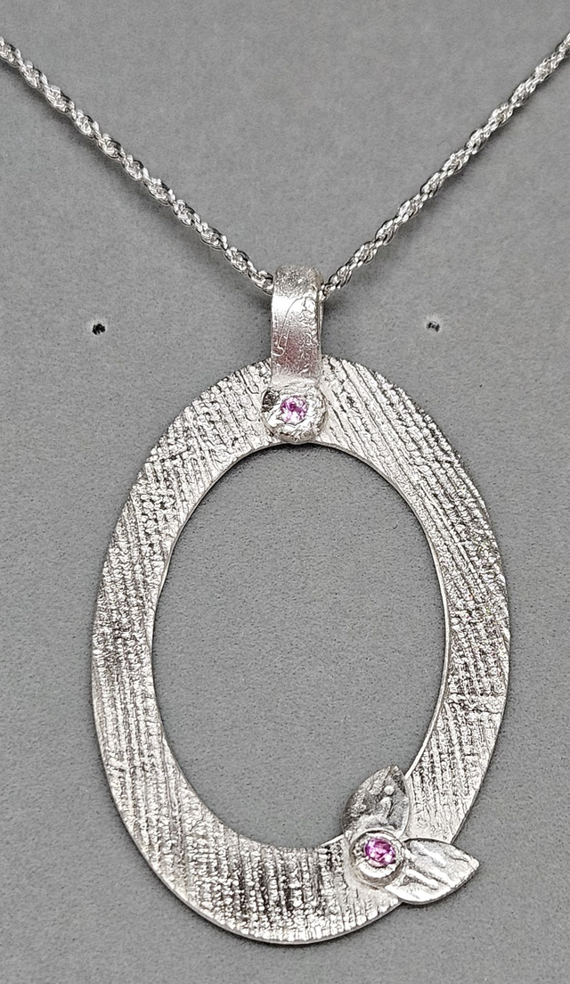 Open oval pendant with pink cubic zirconias