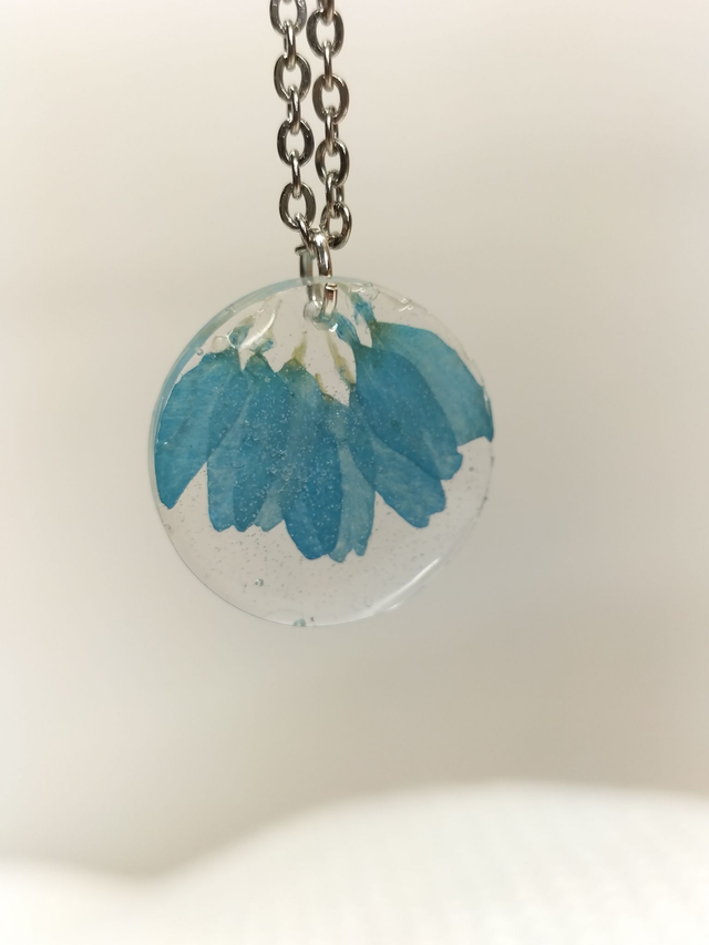 Pendentif rond et pétales de fleurs bleus