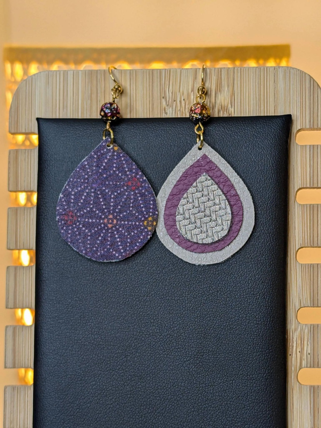 Boucles d'oreilles pendante en similicuir et en tissus enduit violet, gris argenté. avec des perles naturelles le fermoir de la boucle est en or. 