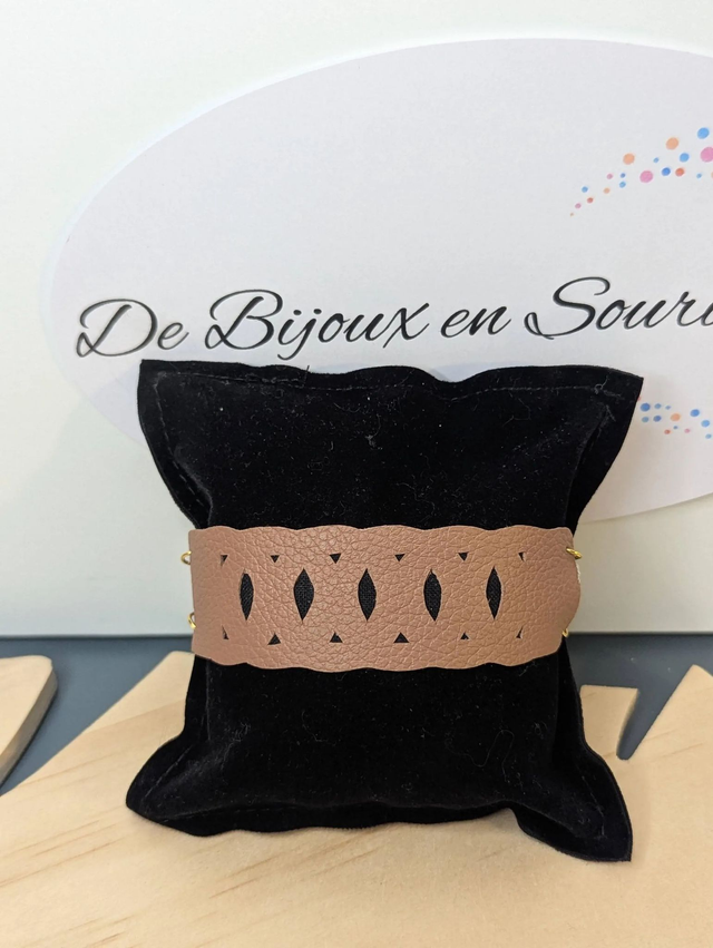 Bracelet manchette en cuir marron clair, avec du tissus enduit noir (résistant), une chaine dorée. Le fermoir est de couleur or.