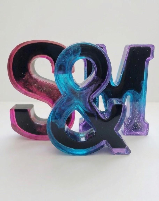 Lettre géante en résine époxy couleur fumée transparente sur fond noir de 15,5cm