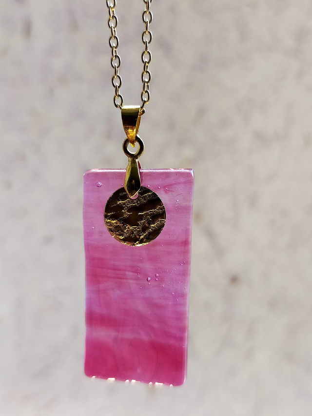 Pendentif en verre rose marbré transparent et chaîne couleur or. 