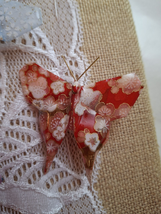 Broche Papillon rouge à fleurs blanches