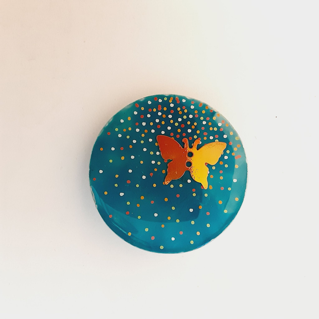 Broche ronde collection Petit point fond turquoise petits points blancs et orange  papillon orange irisé