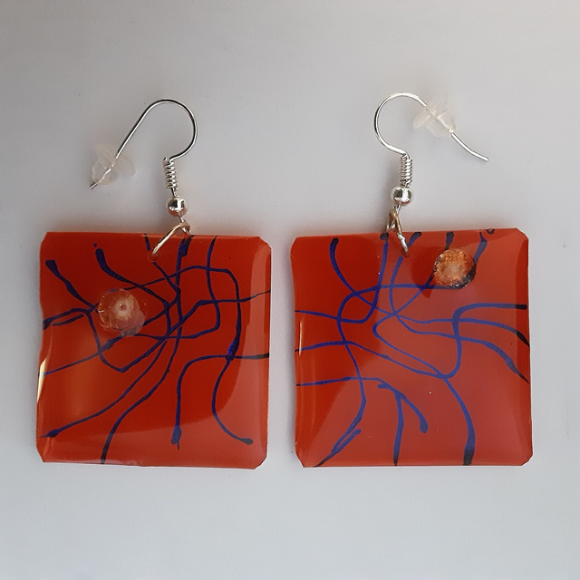 Boucle d’oreille carrée fond rouge orangé  et motif violet métallisé et cabochon doré scintillant