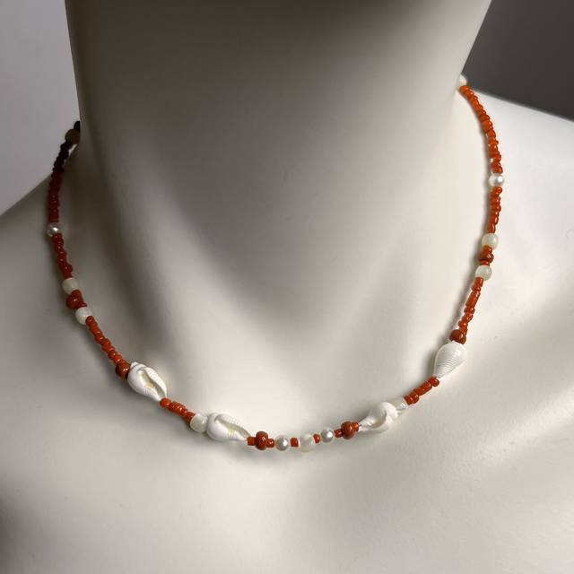 Ketting van koraal met  wulkjes.