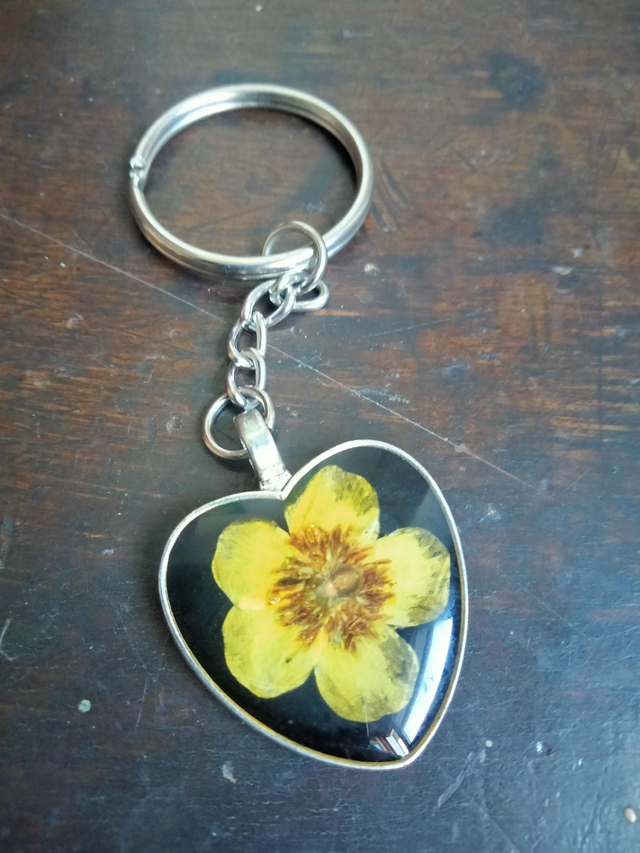 Porte clé forme coeur avec inclusion d'une fleur séchée de bouton d'or 