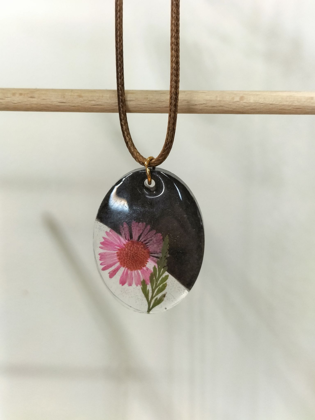 Pendentif ovale noir et fleur séchée