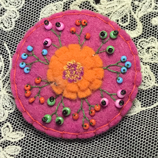 Broche magenta/fleur orange ronde 