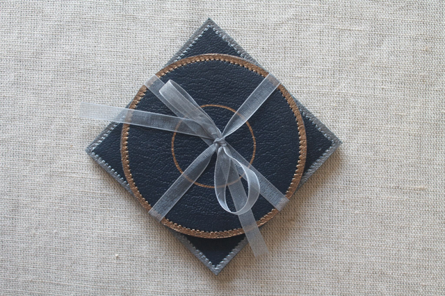 Ensemble de 4 dessous de verre bleu marine, 2 ronds liseré cuivre et 2 carrés liseré argenté