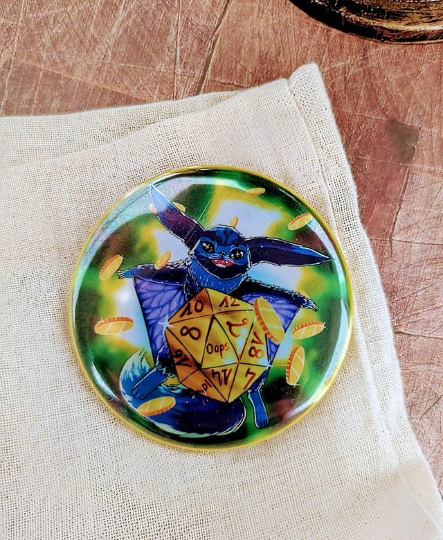 Badge "Sinumura Oops" - 58 mm - effet Métallique