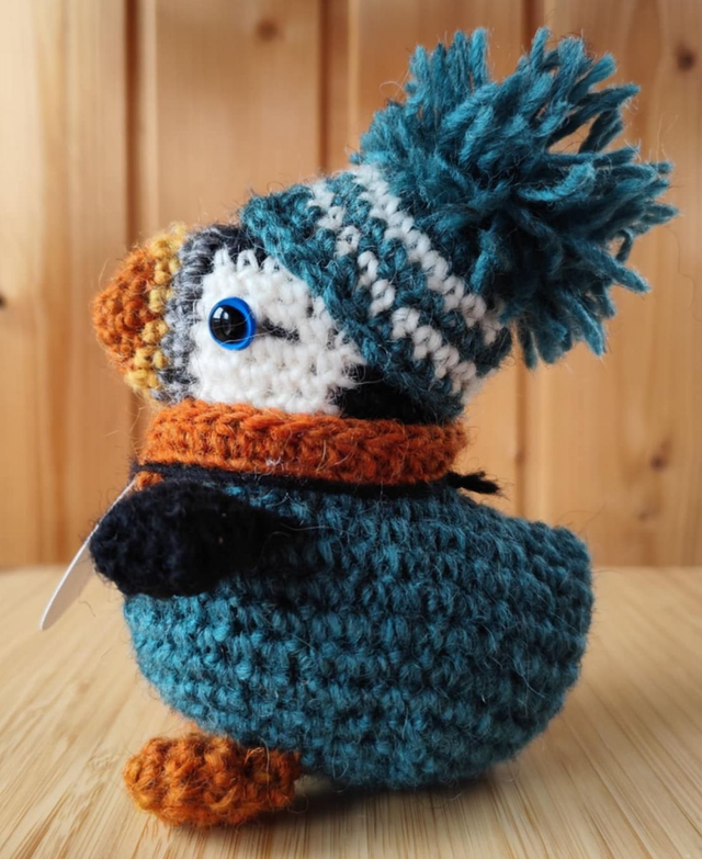 Goofy the puffin wearing bottle green sweater, scarve and hat (made from Icelandic wool yarn)