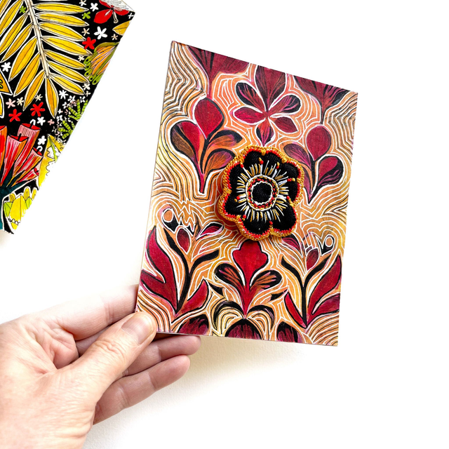 Illustration peinte à l’encre ornée d’une fleur brodée