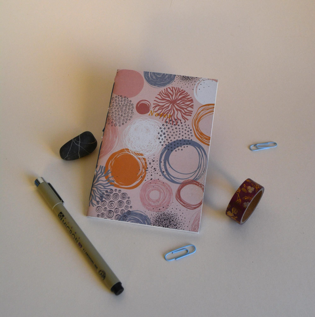 Petit cahier rose à motifs circulaires 