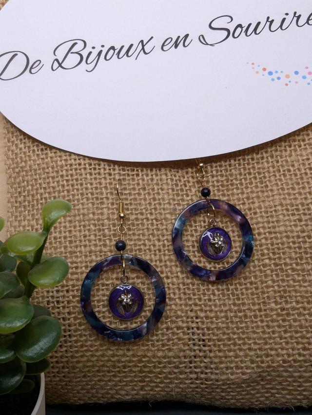 Boucles d&#039;oreilles avec 2 pendentifs, cercle en résine coloré bleu violet, avec des fleurs séchées, des perles naturelle et un fermoir en or. 