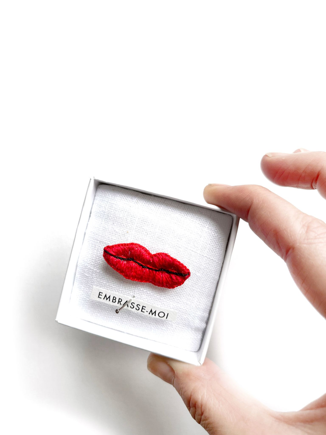 Bouche rouge brodée dans boîte vitrine