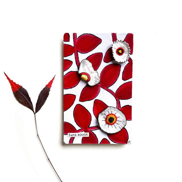 Tableau rouge et blanc et orné de broderies