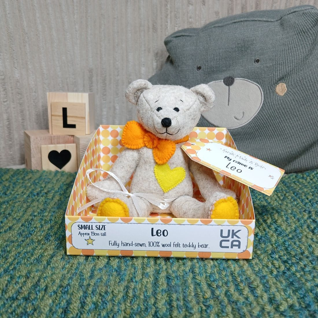 Leo. Small size, handmade teddy bear. UKCA. Tray base packaging. Standard Wool Felt. Fluffy beige. Yellow. Orange.