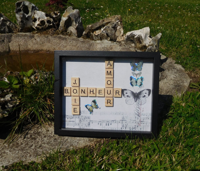 Cadre noir avec lettres de scrabble et papillons