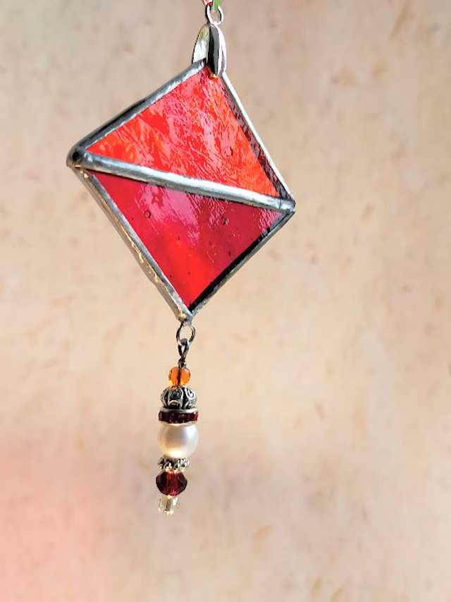 Pendentif en verres rouges sertis en Tiffany,  et chaîne en coton ciré orangé.