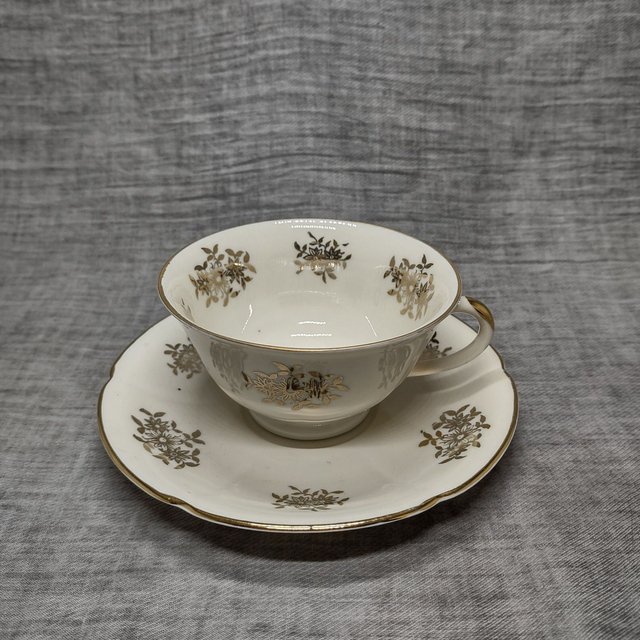 Mosa | Kop en Schotels (kop diameter 10 | hoogte 6 | schotel diameter 14,5 | hoogte 2,5 cm) crème gouden bies bloemmotief | Vintage