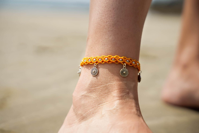 Jolie bracelet de cheville orange avec ses breloques argentées - ajustable