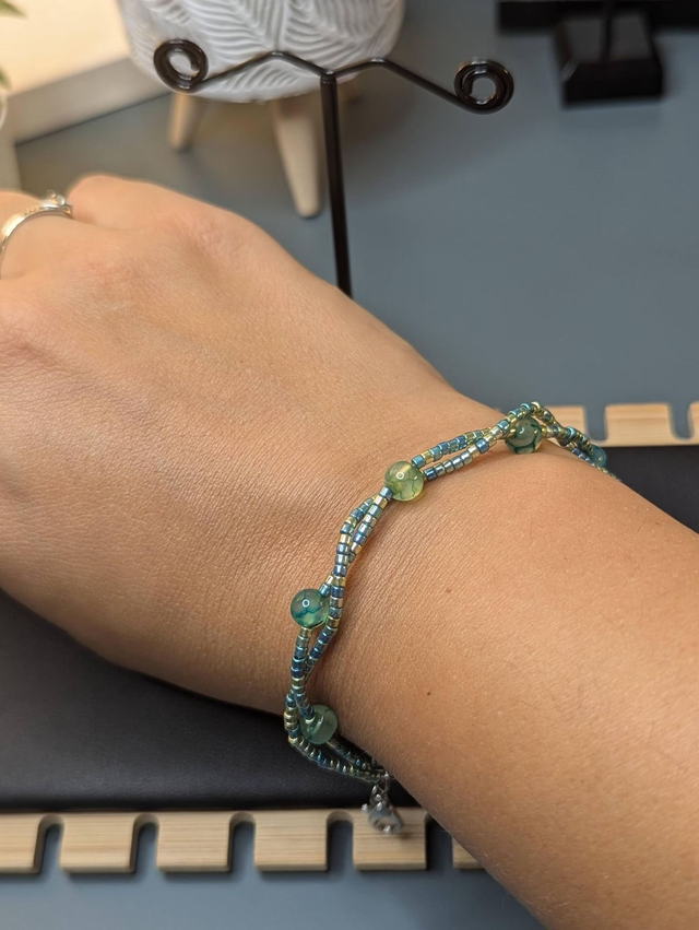 Bracelet torsadé vert avec des perles de  Miyuki en verre et des perles naturelles, montées sur fil de fer. Le fermoir est en couleur argenté.