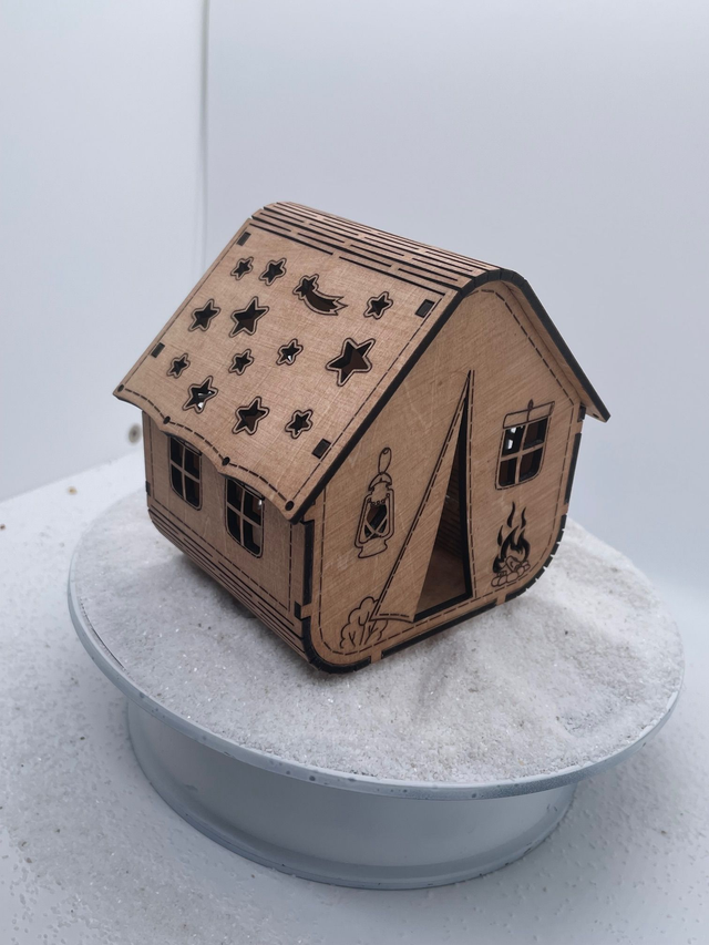 Photophore en bois en forme de tente de camping.