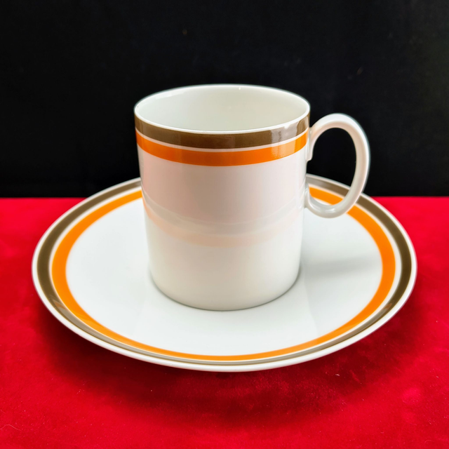 Thomas | Kop (diameter 6,0 cm | hoogte 7,0 cm) en schotel (diameter 15,0 cm | hoogte 2,5 cm) met Bruine en Oranje bies | Vintage