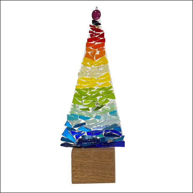 Multi-coloured tall Christmas tree on wooden stand 