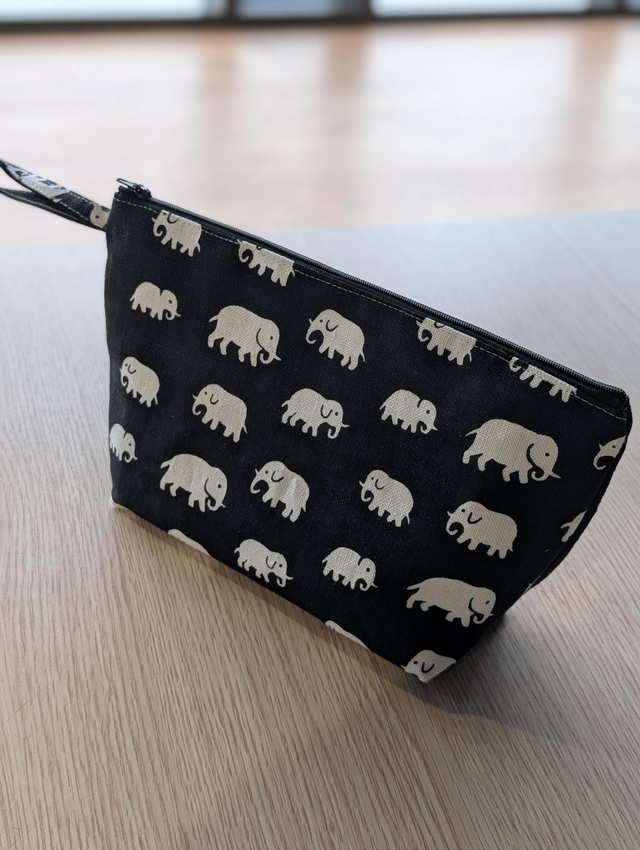 TROUSSE 

 Trousse Artisanale &quot;tissu Éléphant blanc imprimé sur tissu noir&quot; -  Dimensions : 28 x 15 x 8 cm – Fond de la trousse (fabrication artisanale de)

