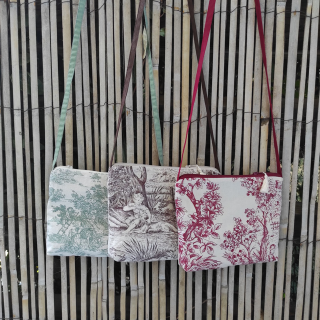Pochette avec bandoulière en tissu toile de Jouy, agrémentée d'un pompon