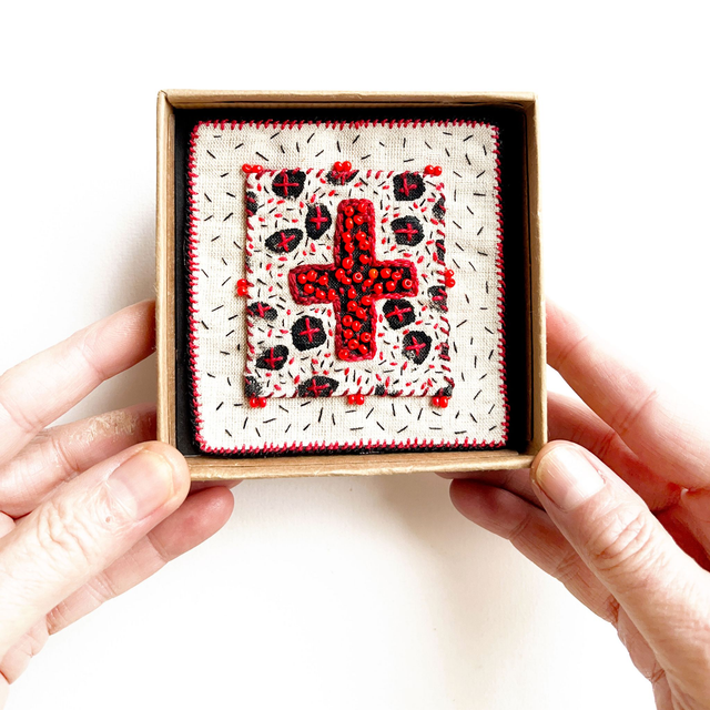 Tableau croix rouge porte-bonheur, richement brodé de fil et de perles
