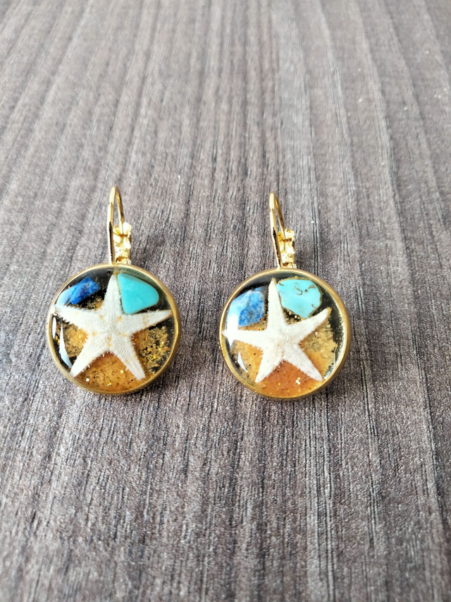Boucle d'oreille crochet en laiton forme ronde couleur dorée avec insertion d'une étoile de mer avec de la résine époxy