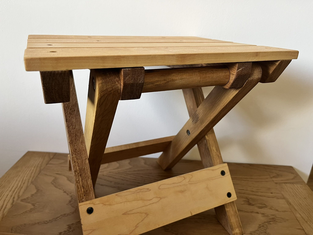 Wooden, folding camping stool made of oak and maple wood.
