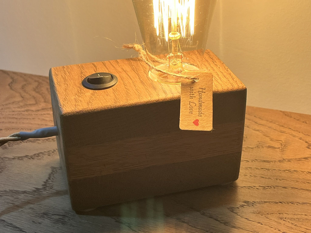 Rustic bedside lamp made of oak wood with a switch and an Edison bulb.