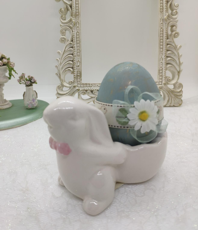 Ceramic bunny with pink bow holding a duck egg 