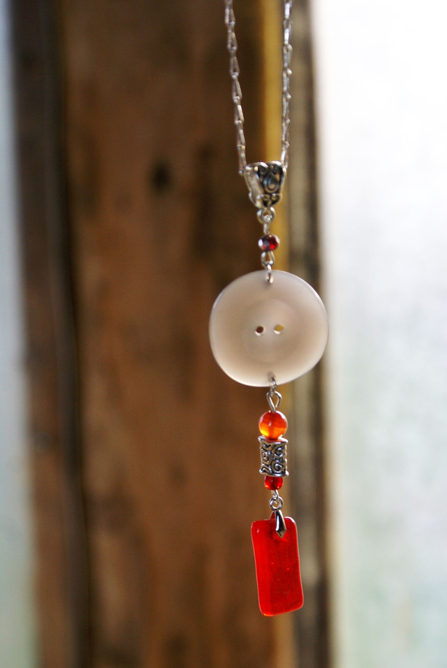 Pendentif en verre rouge transparent et chaîne couleur argent.