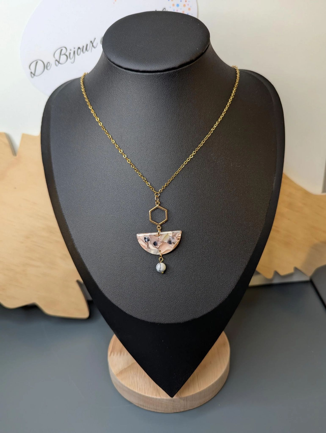 Collier mi long avec une chaine de couleur or et un pendentif en résine rose et noir et un pendentif en métal doré.