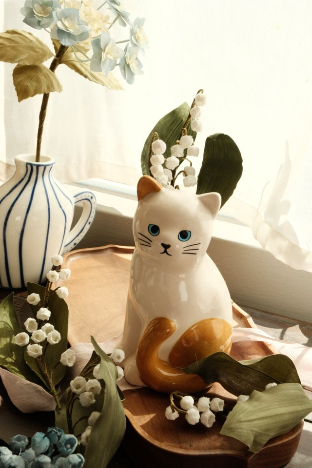Lily of the valley in cat vase